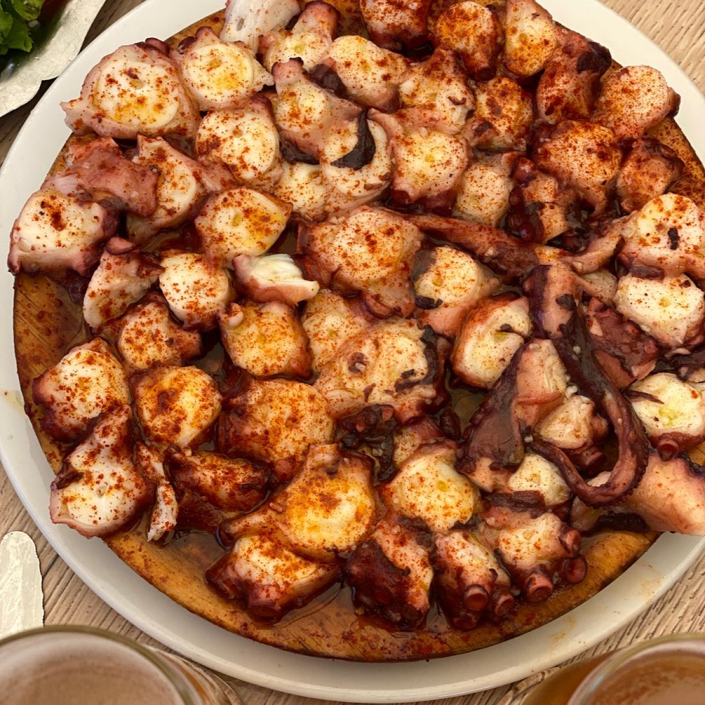 Poulpe grillé au paprika sur assiette blanche